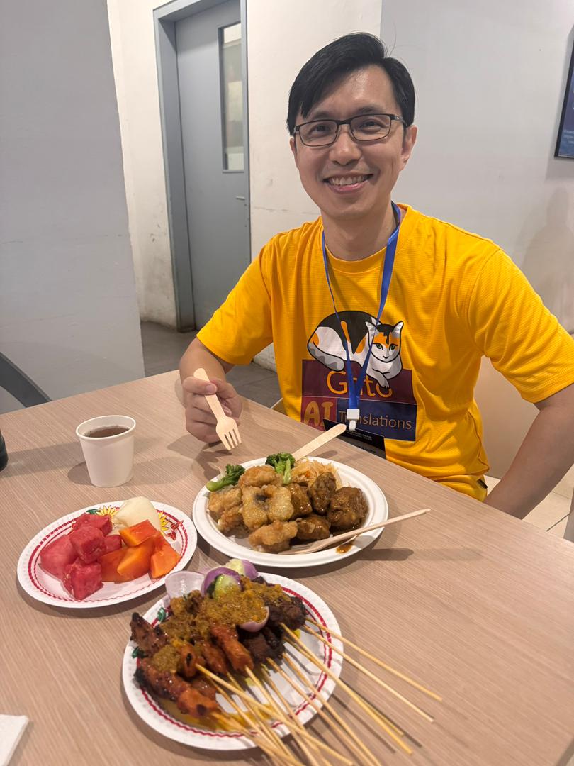 David Wang, amico di Gato, gusta un satay al WordCamp Malaysia 2025